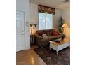 Cozy living room featuring a floral valance, plush sofa and a vintage white coffee table at 976 Dancing Vines Ave, Las Vegas, NV 89183