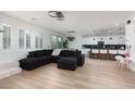 Bright and open living space with a modern sectional sofa and wood-look floors at 12346 Valley Chase Ave, Las Vegas, NV 89138