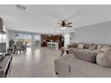 Spacious open-plan living room with tile flooring, a ceiling fan, and a comfortable sectional sofa at 1606 Wild Grain Ave, North Las Vegas, NV 89086