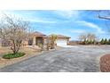 Desert home with a terracotta roof, well-manicured shrubs and circular driveway at 1830 E Fuchsia St, Pahrump, NV 89048