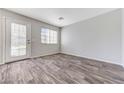 Bright, airy living space featuring neutral walls, wood flooring, and a glass door to the outside at 2621 Adelante Ave # 104, Las Vegas, NV 89106