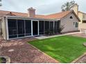 Relaxing backyard featuring a screened-in porch, small patch of artificial turf, and desert landscaping at 3316 Cutty Sark St, Las Vegas, NV 89117