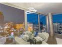 Elegant dining area with glass table and modern lighting, framing stunning cityscape views through expansive windows at 3722 Las Vegas Blvd # 2904, Las Vegas, NV 89158