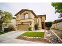 Two-story home featuring a two-car garage, arched windows, red front door and manicured lawn at 3916 Broad Meadow Ct, Las Vegas, NV 89129