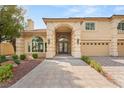 Beautiful two-story house featuring a stone archway, a three-car garage, and paved driveway at 4195 Balmoral Castle Ct, Las Vegas, NV 89141