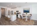 Bright kitchen featuring white cabinets, stainless steel appliances, an island with seating, and a dining table at 600 N Carriage Hill Dr # 2174, Las Vegas, NV 89138