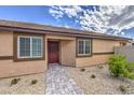 Single-story home with covered entry, stone walkway, desert landscaping, and neutral stucco at 7910 Pandora Sky St # 271, North Las Vegas, NV 89084