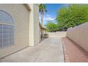 Private and spacious side yard with a covered patio, desert landscaping, and a stucco wall at 880 Autumn Canyon Way, Henderson, NV 89002