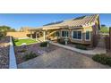 Private backyard oasis featuring a covered patio, artificial turf, desert landscaping, and a charming water fountain at 917 Pigeon Forge Ave, Henderson, NV 89015