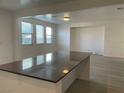 Kitchen island with granite countertop adjoins a living room with ample sunlight at 953 Via Gandalfi, Henderson, NV 89011