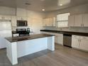 Bright kitchen featuring white cabinets, stainless steel appliances, and a spacious island at 953 Via Gandalfi, Henderson, NV 89011