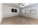 Neutral living room featuring tile floors, modern ceiling fan, and large windows for ample natural light at 9807 Sage Canyon St, Las Vegas, NV 89178