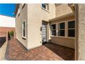 View of side yard and backdoor patio area with brick pavers and stucco walls at 9807 Sage Canyon St, Las Vegas, NV 89178