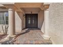 Inviting front entrance featuring a secure metal gate, decorative columns, and stylish brickwork leading to the door at 9967 Pipestone St, Las Vegas, NV 89141