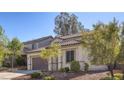 Side view of a two-story home with a tile roof and manicured landscaping, including a two-car garage at 1077 Lemongrass Ct, Henderson, NV 89002