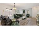 Staged living room showcasing modern decor, including a comfortable sofa, stylish rug, and abundant natural light at 1077 Lemongrass Ct, Henderson, NV 89002