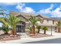 Charming two-story home featuring a tile roof, stone accents, and a well-manicured yard with palm trees at 3088 Via Flaminia Ct, Henderson, NV 89052