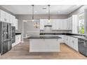 Well-lit kitchen with modern stainless steel appliances, white cabinets, and an island with a dark countertop at 3088 Via Flaminia Ct, Henderson, NV 89052