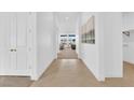Bright hallway with white walls, tile flooring, and a view into the living area showcasing an open layout at 5030 Sandline Court, Las Vegas, NV 89135
