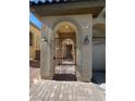 Close up of entry gate with decorative wrought iron and arched entry with lighting fixtures at 5937 Armide St, North Las Vegas, NV 89081
