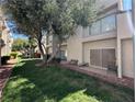 Backyard patio area with sliding door, lush green grass, mature tree, and space for seating at 6250 W Flamingo Rd # 143, Las Vegas, NV 89103