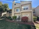 Exterior view of a two-story condo building with a well-maintained lawn, bushes, and trees at 6250 W Flamingo Rd # 143, Las Vegas, NV 89103