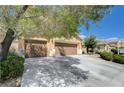 Wide driveway leading to a three-car garage, framed by lush greenery and mature trees at 6656 Fort William St, North Las Vegas, NV 89084