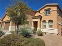 Beautiful tan two-story home featuring desert landscaping in a well-maintained yard at 6656 Fort William St, North Las Vegas, NV 89084