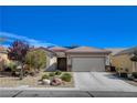 Charming single-story home featuring a well-manicured yard, desert landscaping, and a convenient two-car garage at 7564 Wingspread St, North Las Vegas, NV 89084