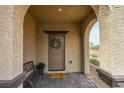 Inviting front porch with decorative wreath, charming bench and welcome mat, creating a warm and friendly entrance at 9160 Lynea Ct, Las Vegas, NV 89178