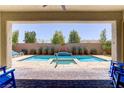 Inviting covered patio with a view of the pool and lush backyard for luxurious outdoor living at 9779 Mosaic Canyon Ct, Las Vegas, NV 89149