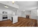 Bright open-concept living room with wood flooring, fireplace, and direct kitchen access at 9901 Trailwood Dr # 2144, Las Vegas, NV 89134