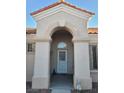 Arched front entryway featuring a security door, desert landscaping, and neutral colors at 9937 Villa Ridge Dr, Las Vegas, NV 89134