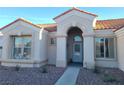 Front yard featuring desert landscaping and arched entrance, creating a welcoming approach at 9937 Villa Ridge Dr, Las Vegas, NV 89134