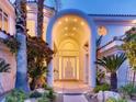 Grand entrance with arched doorway, white columns, lush landscaping, and modern lighting at 10 Innisbrook Ave, Las Vegas, NV 89113