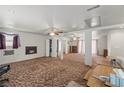 A spacious basement featuring a fireplace, ceiling fans, support columns, and wall to wall carpeting at 1160 Huracan St, Pahrump, NV 89048