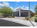 Modern single-story home with gray stucco, desert landscape, and a paved driveway at 1609 Dream Canyon Ave, North Las Vegas, NV 89084