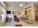 Comfortable living area with leather seating, a ceiling fan, and lots of natural light from a large window at 2037 Poppywood Ave, Henderson, NV 89012