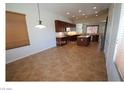 Spacious kitchen and dining area with dark wood cabinets, stainless steel appliances, and tile floors at 2324 Orangeburg Pl, Henderson, NV 89044
