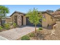 Charming single-story home with stone facade, neutral paint, dark garage door and low maintenance landscaping at 243 Sun Glaze Ave, Henderson, NV 89011