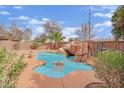 Backyard pool featuring rock waterfall, mature trees, and low-maintenance landscaping at 3221 Birdwatcher Ave, North Las Vegas, NV 89084