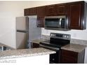 Updated kitchen with granite counters, stainless appliances, and wooden cabinets at 5130 S Jones Blvd # 108, Las Vegas, NV 89118