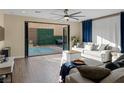 Bright living room with hardwood floors, a comfortable sofa, and folding doors leading to the pool at 6021 Vista Clara St, Las Vegas, NV 89148
