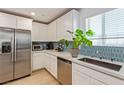 Bright kitchen featuring white cabinets, stainless steel appliances, and a stylish backsplash at 6208 Rathbone St, Las Vegas, NV 89166