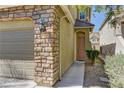 View of house number on a stone front with walkway leading to a light pink front door at 6457 Lovett Canyon St, Las Vegas, NV 89148