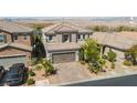 Aerial view of a two-story home featuring a tile roof, desert landscaping, and brick driveway at 7837 Hamilton Pool Dr, Las Vegas, NV 89113