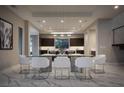 Modern dining room with marble floors, glass table, and contemporary chairs next to kitchen at 80 Glade Hollow Dr, Las Vegas, NV 89135