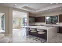 Bright, open kitchen featuring a large island with seating, modern appliances, and tile floors at 80 Glade Hollow Dr, Las Vegas, NV 89135