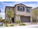 Charming two-story home with stucco facade, stone accents, a two-car garage, and professionally landscaped front yard at 8564 Scalpay St, Las Vegas, NV 89166
