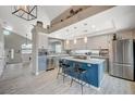 This open concept kitchen has an island with bar seating, gray cabinets, and stainless steel appliances at 8725 Hawk Canyon St, Henderson, NV 89074